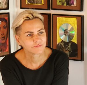 photo of pk mutch, white woman, black top, with colourful art in the background
